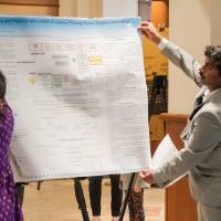 Venkata (right) helping Sabrahmanya (left) set up her poster